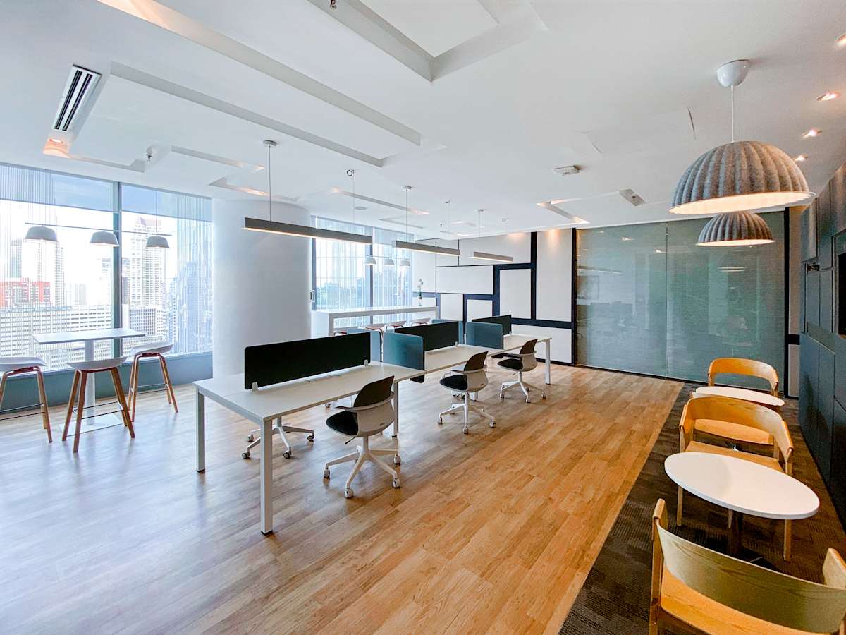 Modern coworking space with sleek desks, ergonomic chairs, and abundant natural light.