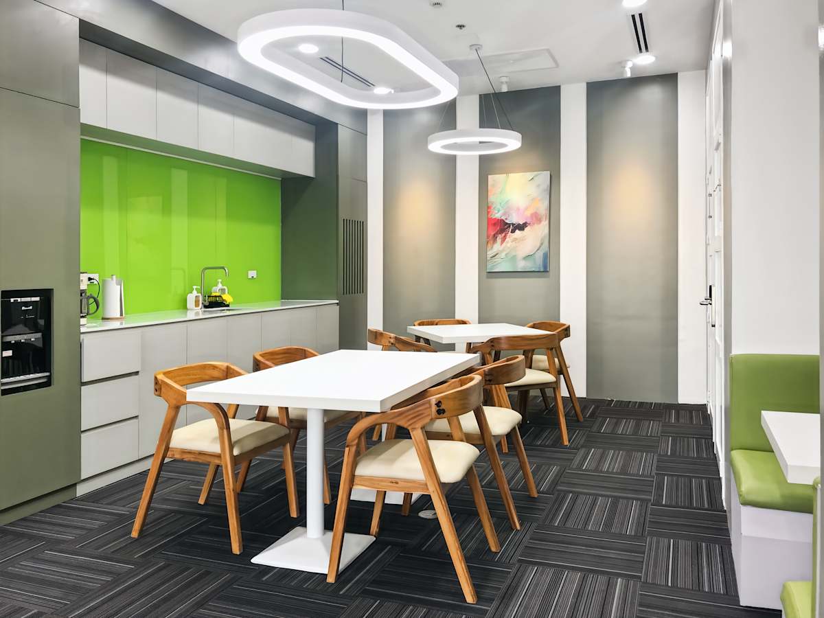 Modern workspace with sleek seating, vibrant green accents, and contemporary lighting.