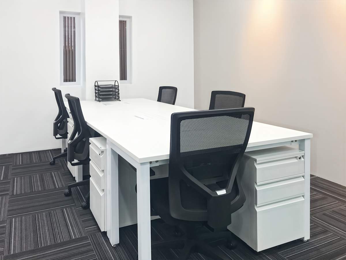 Modern coworking space with sleek desks, ergonomic chairs, and ample natural light.