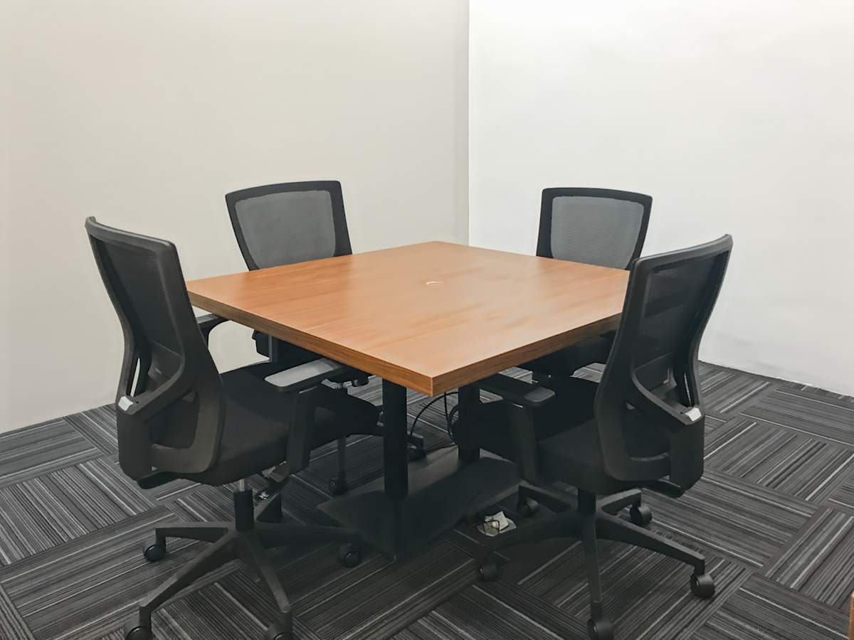 Modern meeting area with a sleek wooden table and ergonomic chairs. Ideal for collaboration.