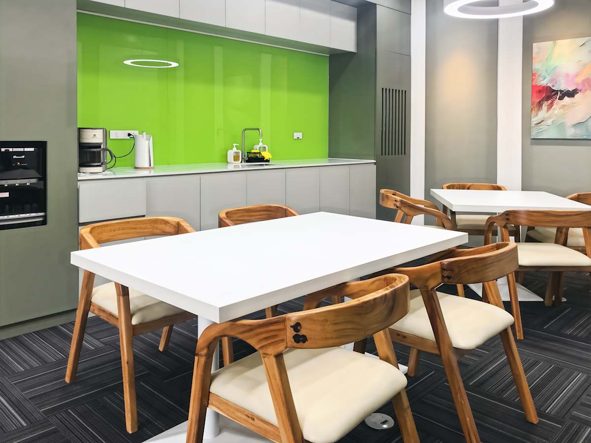 Modern coworking area with chic wood accents and vibrant green backsplash. Bright and inviting.