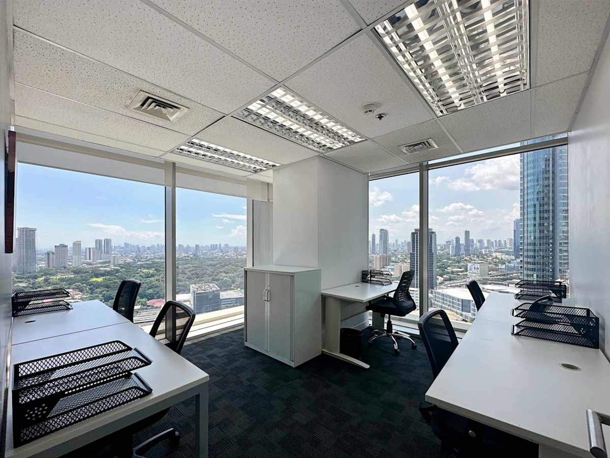 Bright office with expansive city views, modern desks, and ample natural light.