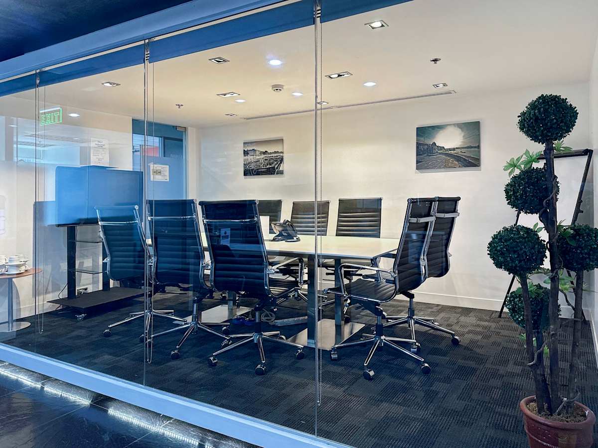 Modern conference room with sleek glass walls, ergonomic chairs, and ambient lighting. Ideal for meetings.