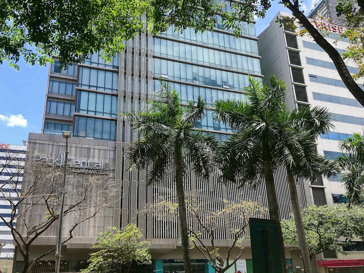 Modern office building with lush landscaping, large windows, and sleek architectural design.