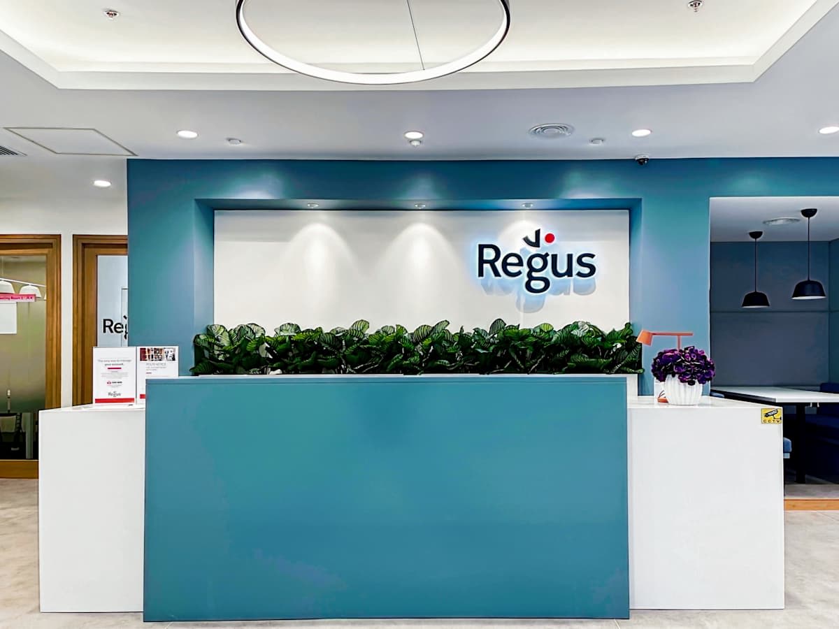 Modern reception area with sleek design, ample lighting, and inviting greenery. Ideal for professionals.