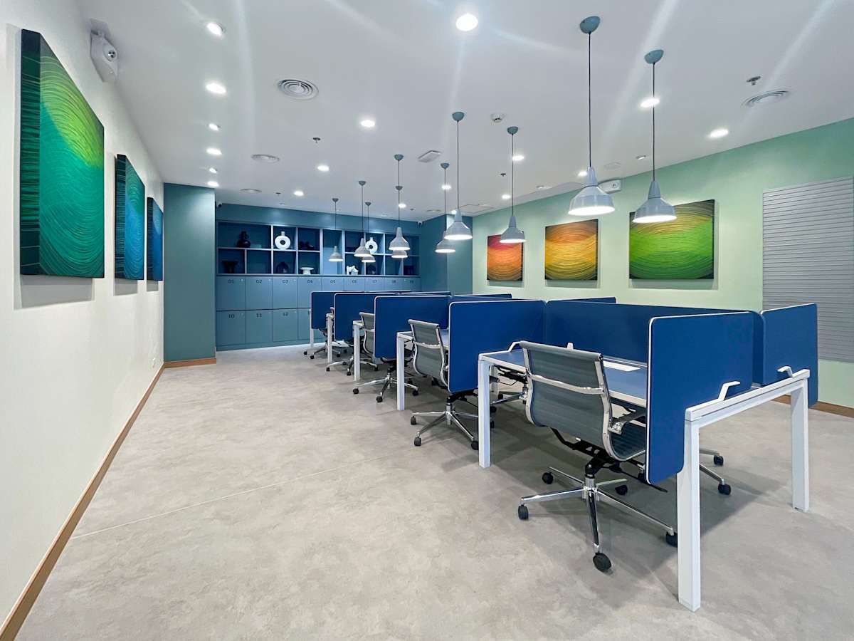 Modern coworking space with sleek workstations, vibrant art, and ample lighting.