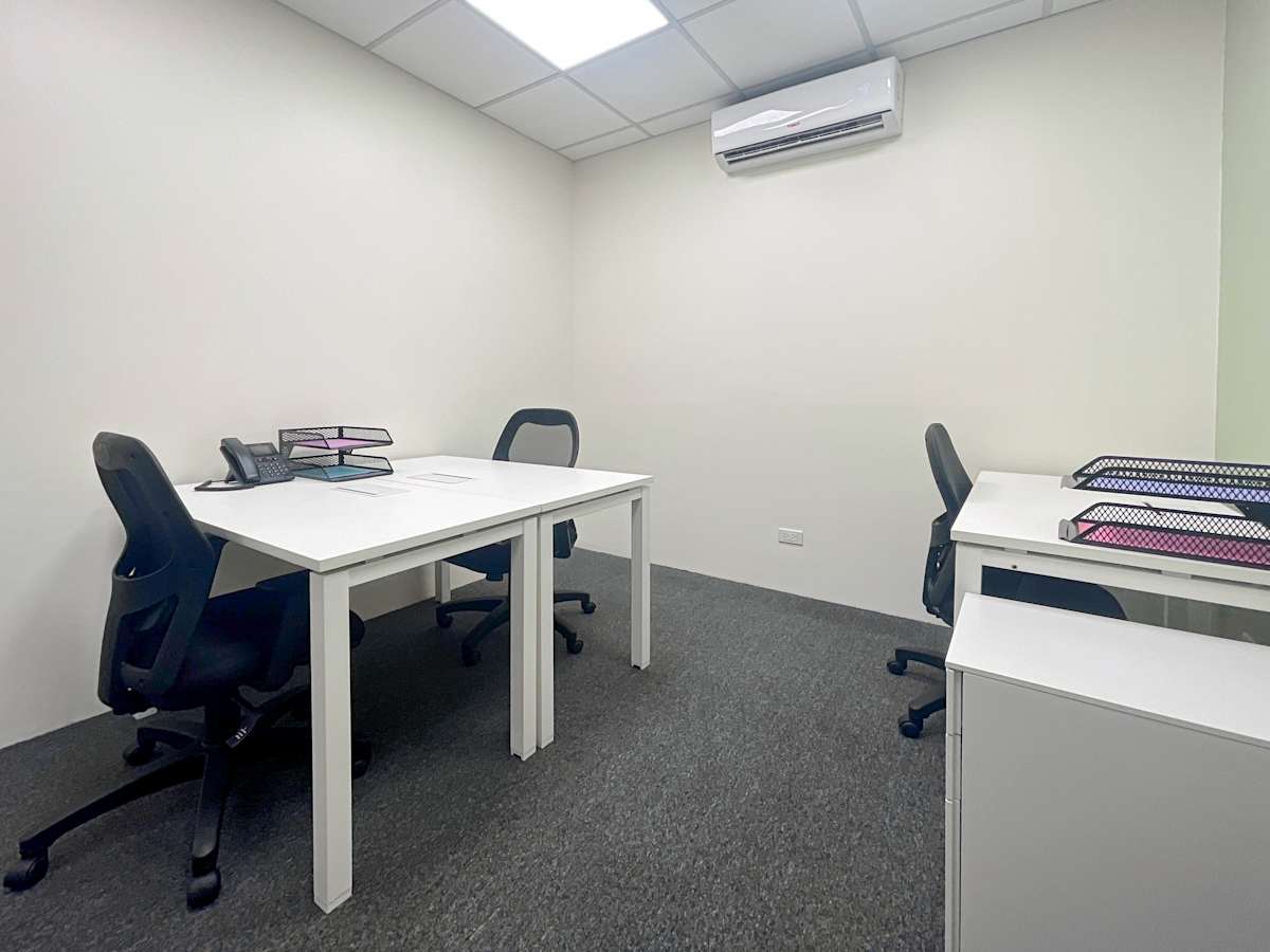 Bright office with modern desks, ergonomic chairs, and ample storage in a serene setting.