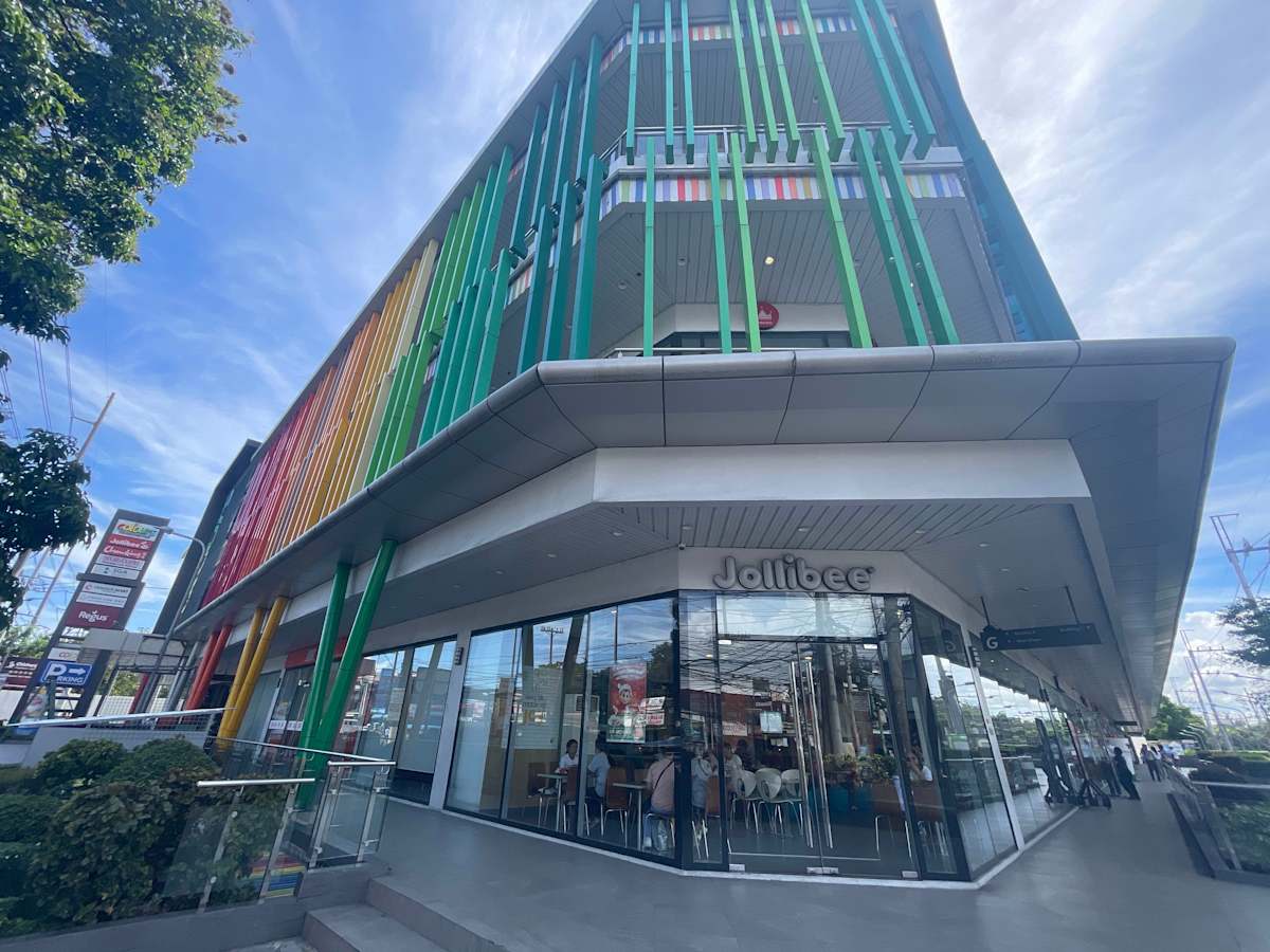 Modern commercial building with vibrant facade, featuring ground-floor retail space.
