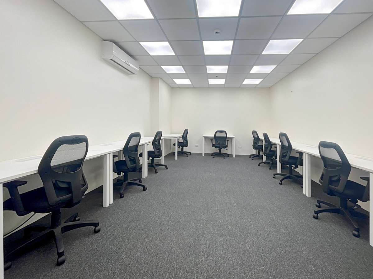 Spacious office with ergonomic chairs and ample desk space, ideal for focused teamwork.