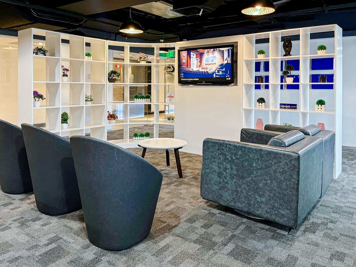 Modern lounge area with sleek chairs, a cozy sofa, and a decorative shelving backdrop.