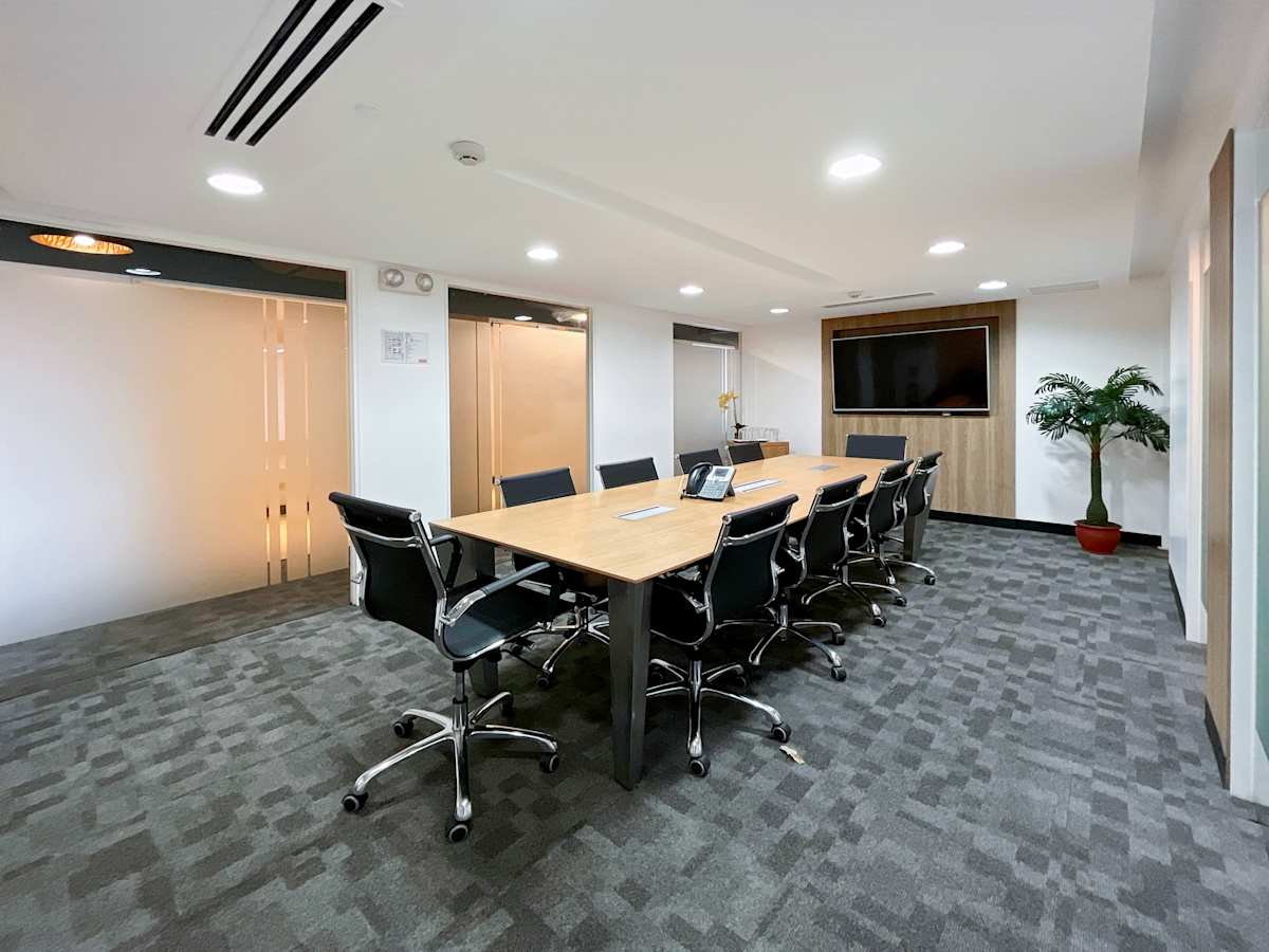 Modern conference room with sleek chairs, large table, and ample lighting. Ideal for meetings.