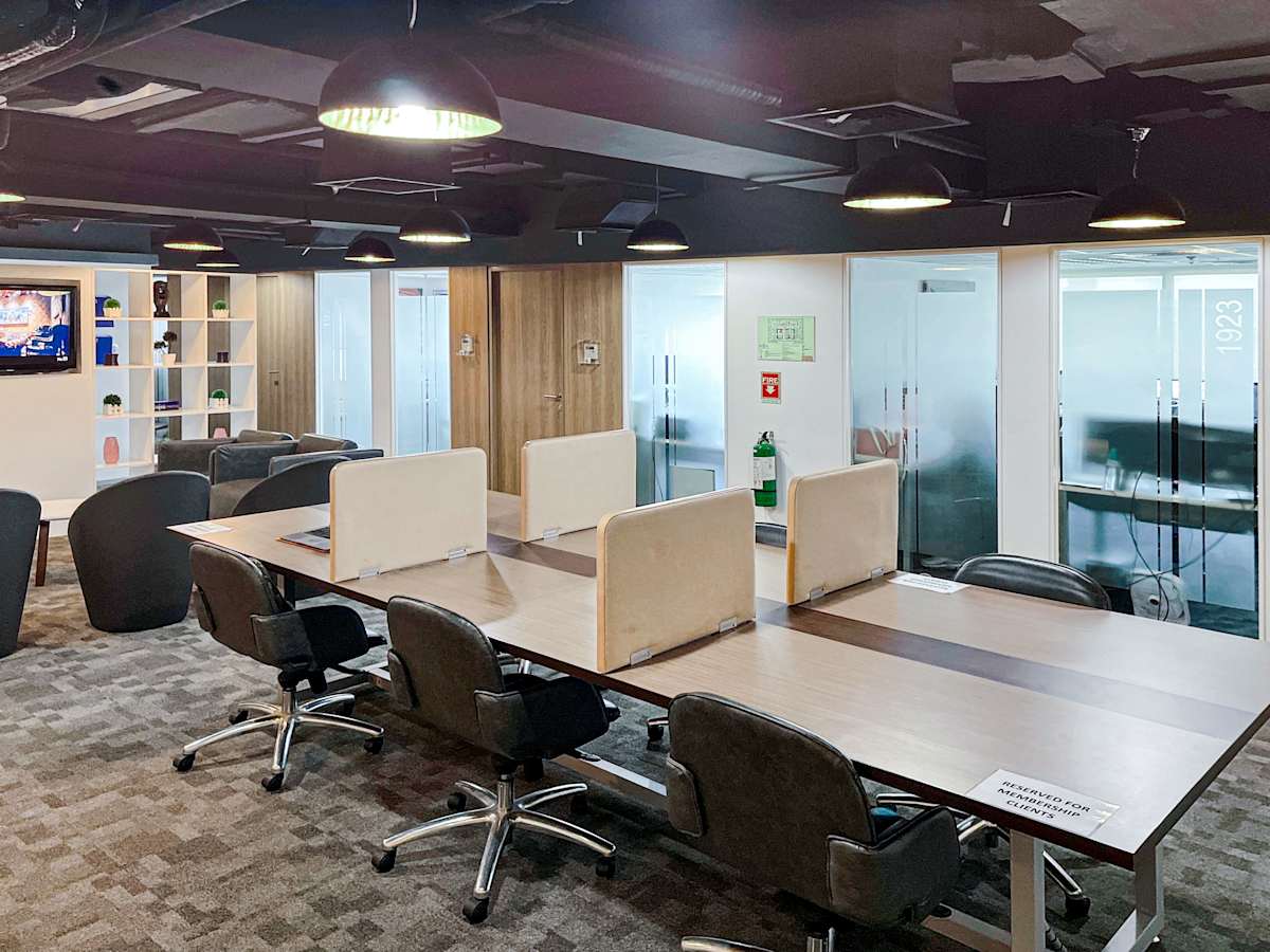 Modern coworking space with ample seating, natural lighting, and private meeting rooms.
