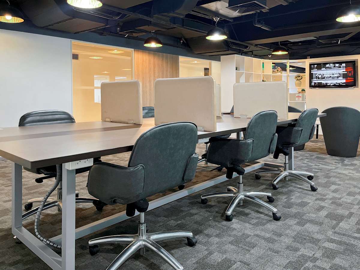 Modern coworking space with ergonomic chairs, shared desks, and ample natural lighting.