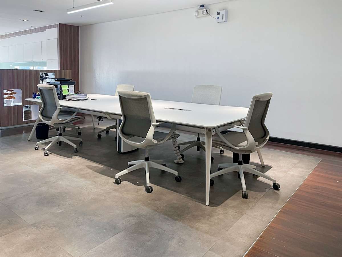 Modern workspace with ergonomic chairs and a spacious meeting table. Ideal for collaboration.