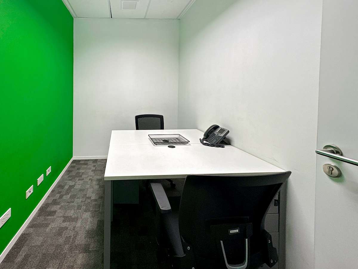 Compact, private office with modern desk, ergonomic chair, and vibrant accent wall.