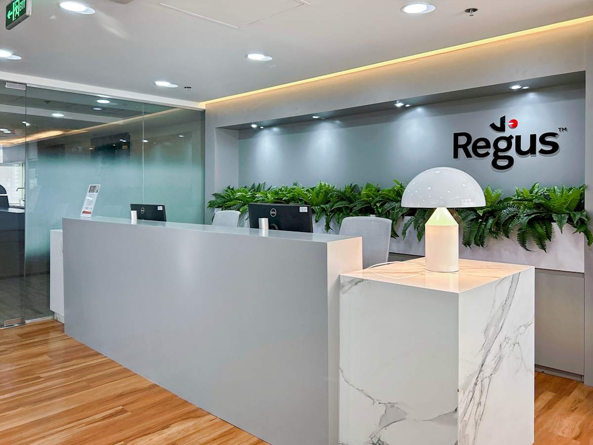 Modern reception area with sleek design, ample lighting, and lush greenery. Perfect for a welcoming workspace.