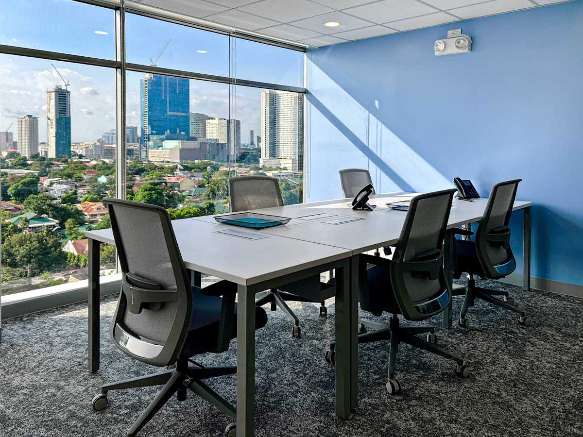 Bright conference room with city views, modern furnishings, and natural lighting. Ideal for meetings.