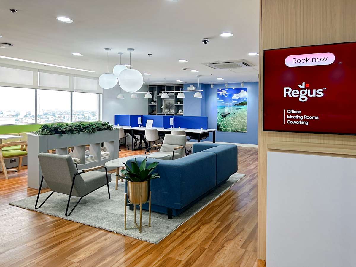 Modern coworking space with ample natural light, cozy seating, and private workstations.