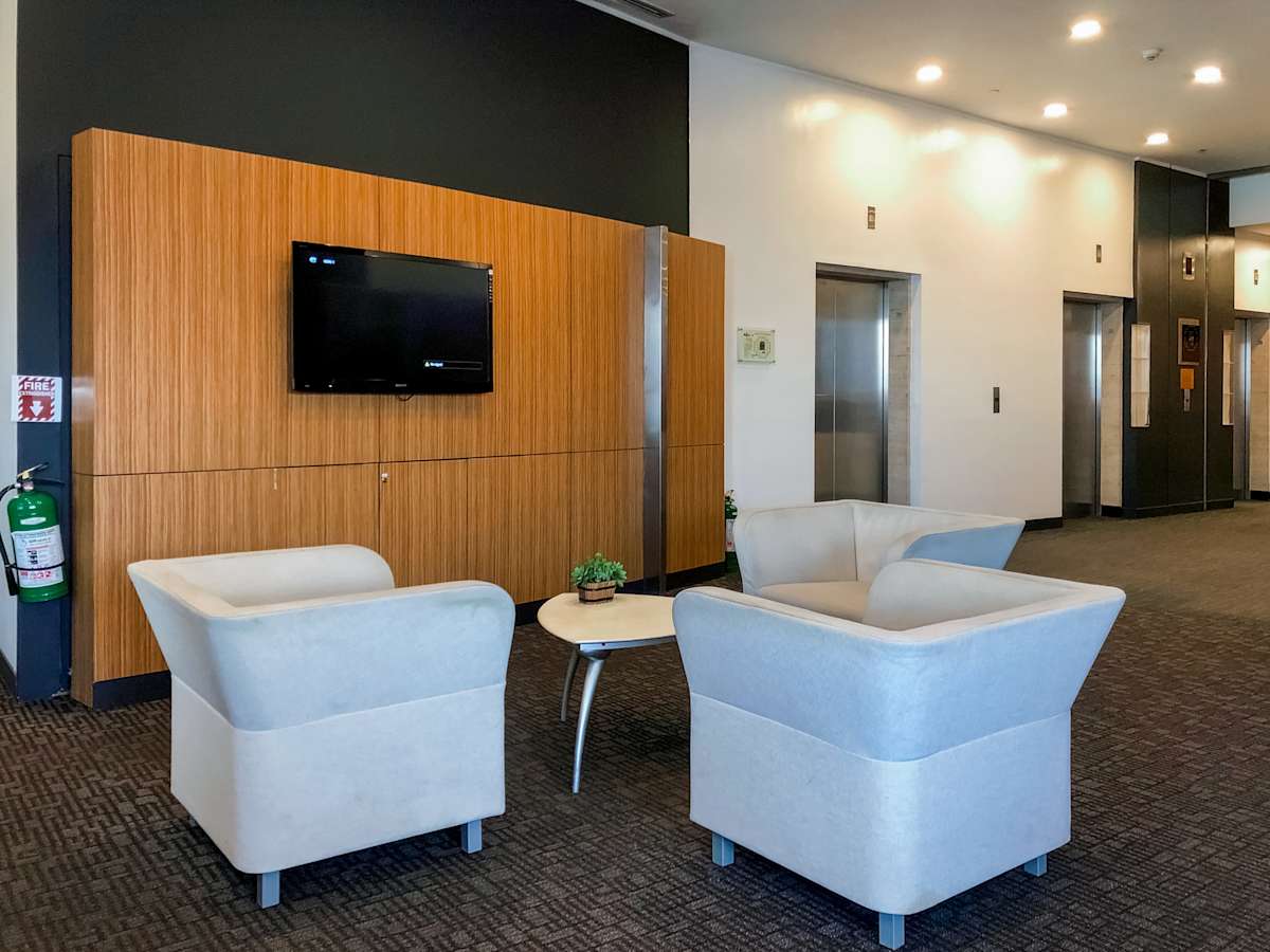 Modern lounge area with plush seating, sleek wall paneling, and ambient lighting. Perfect for meetings.