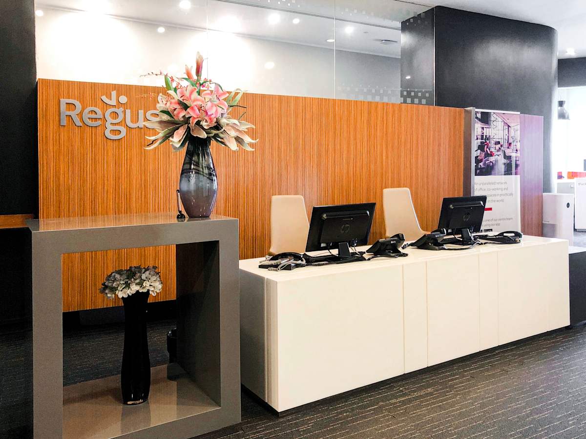 Modern reception area with sleek desks and vibrant floral decor. Ideal for welcoming clients.