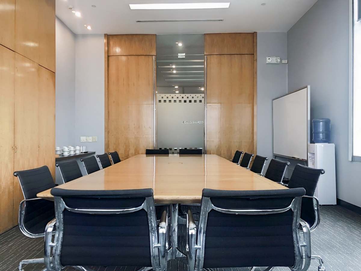Modern conference room with sleek chairs, a large table, and ample natural light.