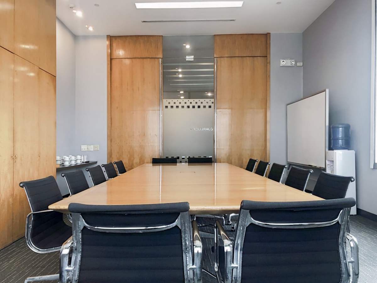 Sleek conference room with modern seating and ample natural light. Ideal for meetings.