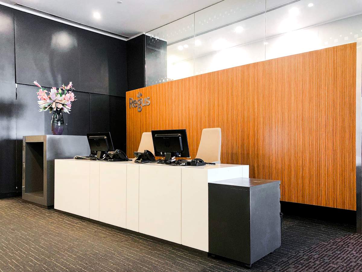 Modern reception area with sleek design, ample lighting, and elegant floral arrangement.