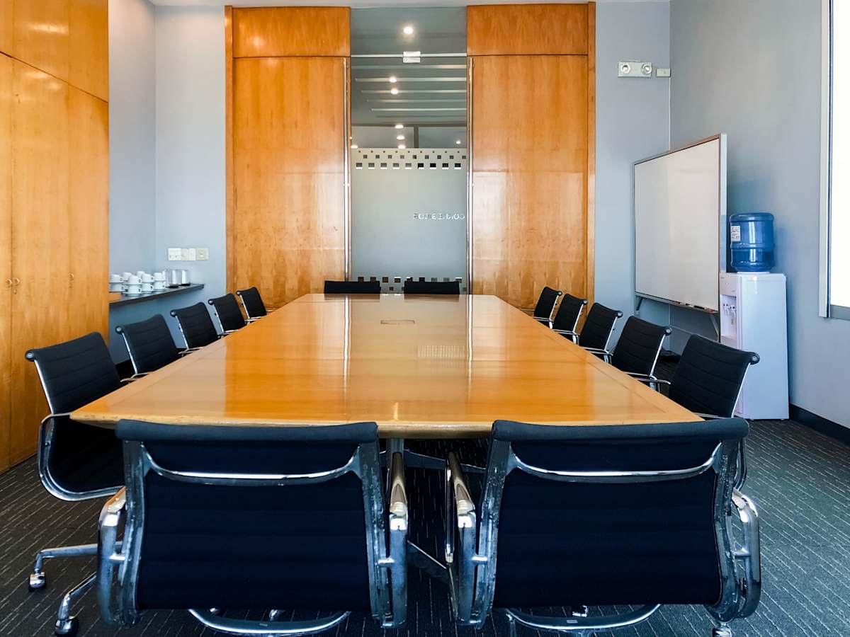 Spacious conference room with sleek black chairs and warm wood accents, ideal for meetings.