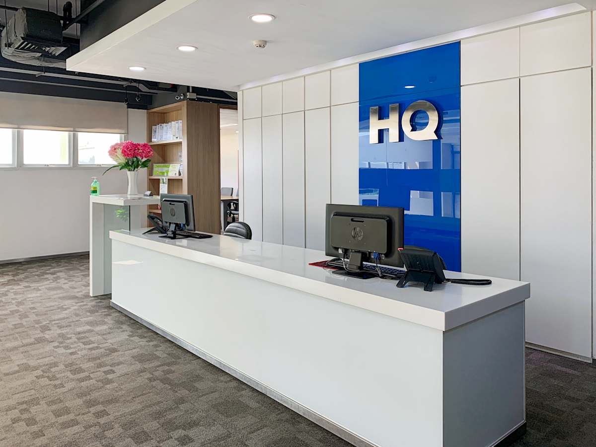Modern reception area with sleek design, featuring ample natural light and dual workstations.
