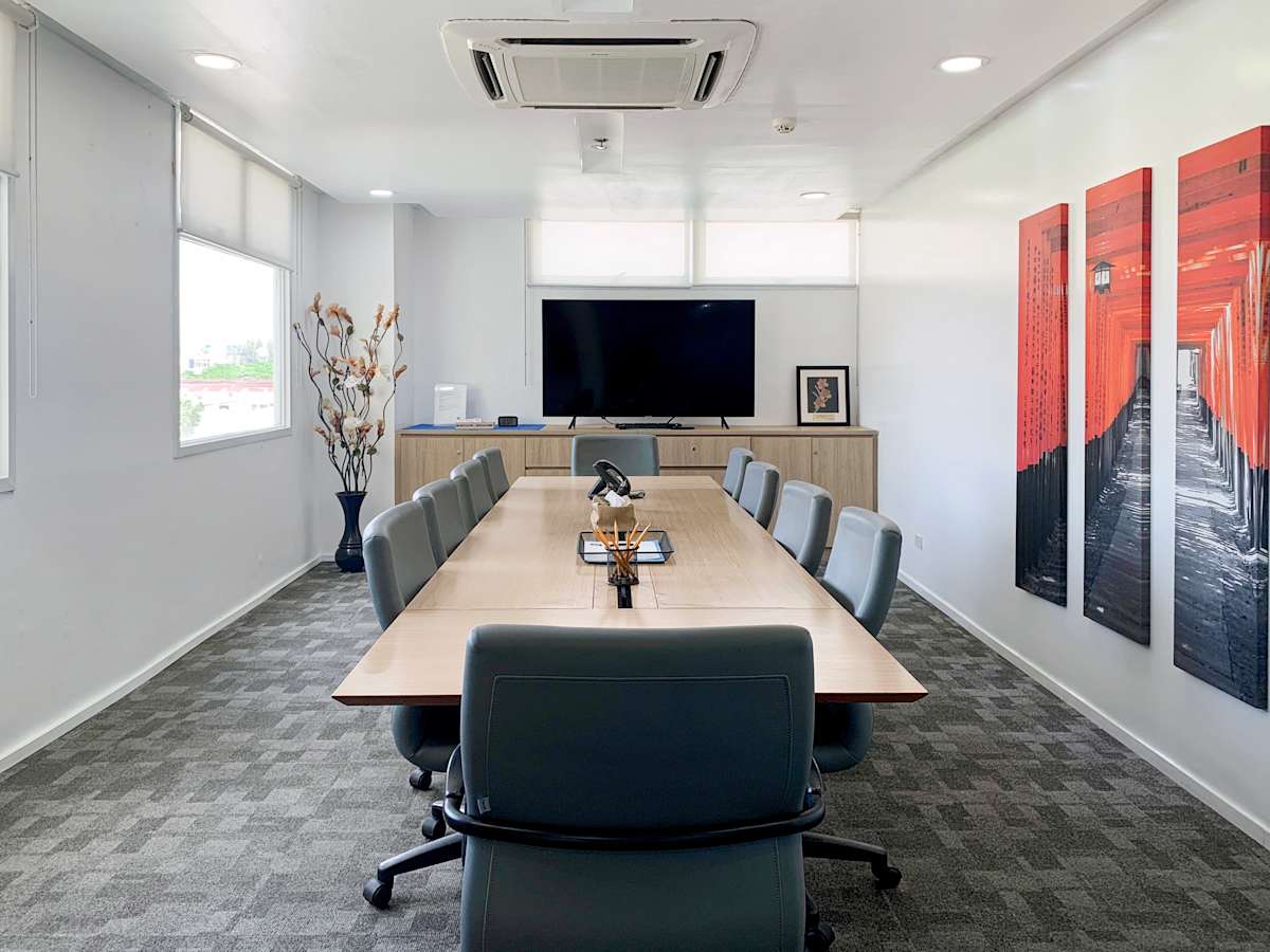 Modern conference room with seating for ten, large screen, and contemporary art accents.