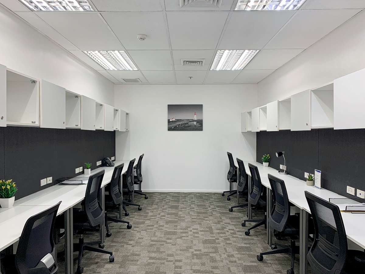 Modern coworking space with sleek desks, ergonomic chairs, and ample storage. Bright and inviting.