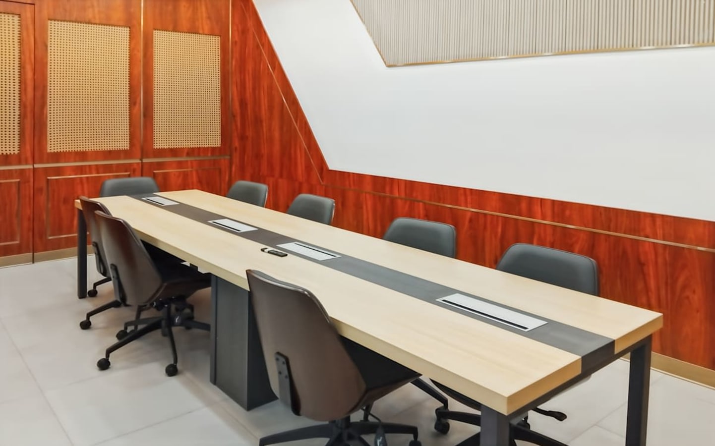 Modern conference room with sleek long table, ergonomic chairs, and stylish wood paneling.