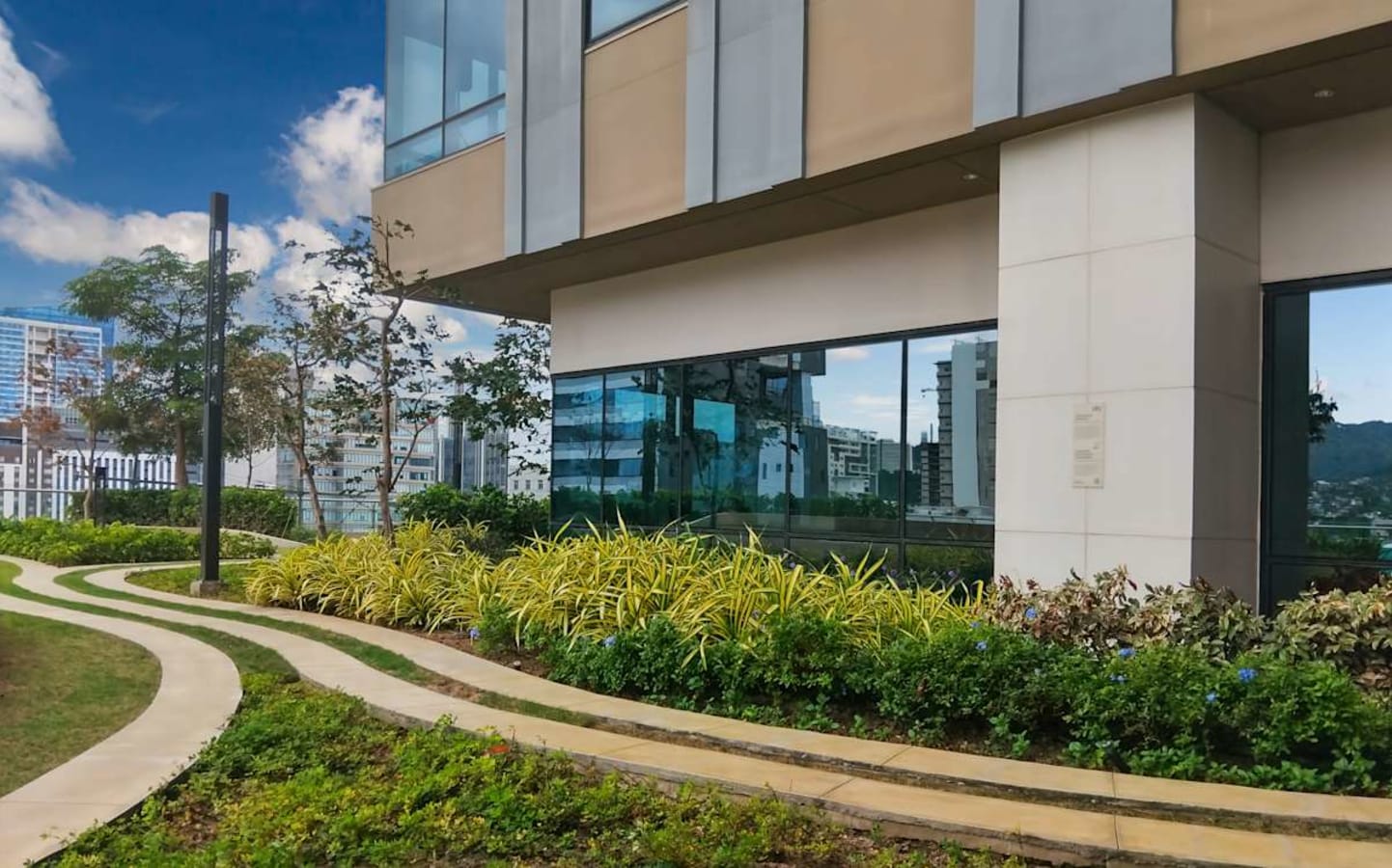 Modern office exterior with lush landscaping and large windows for abundant natural light.