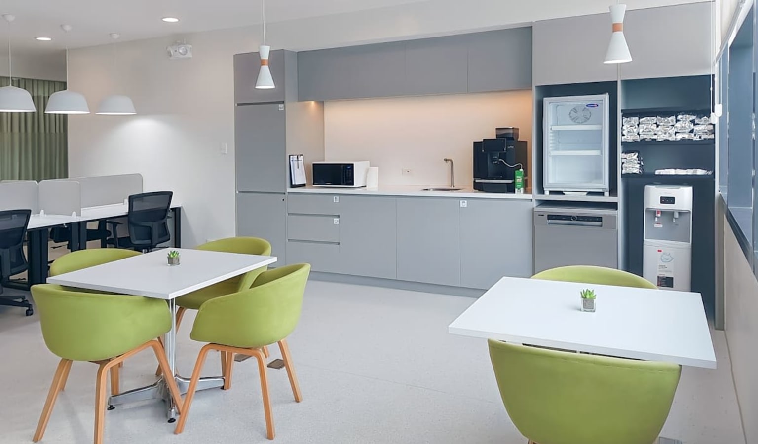 Modern office kitchen with sleek cabinets and cozy seating, perfect for collaboration.