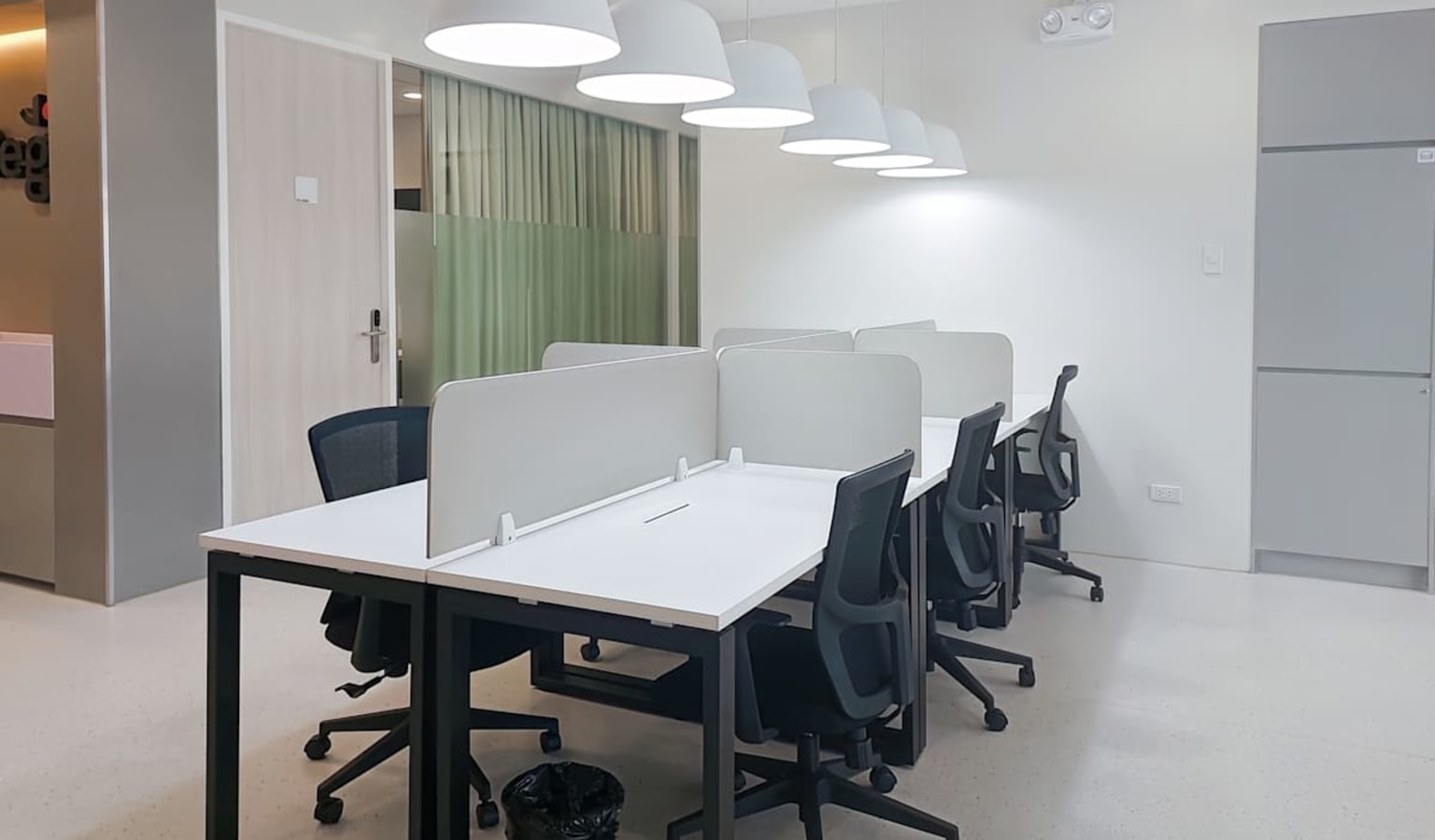 Sleek coworking area with modern desks, ergonomic chairs, and ample natural lighting.