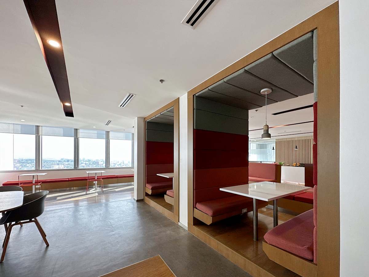 Modern coworking space with stylish booths, ample seating, and stunning city views.
