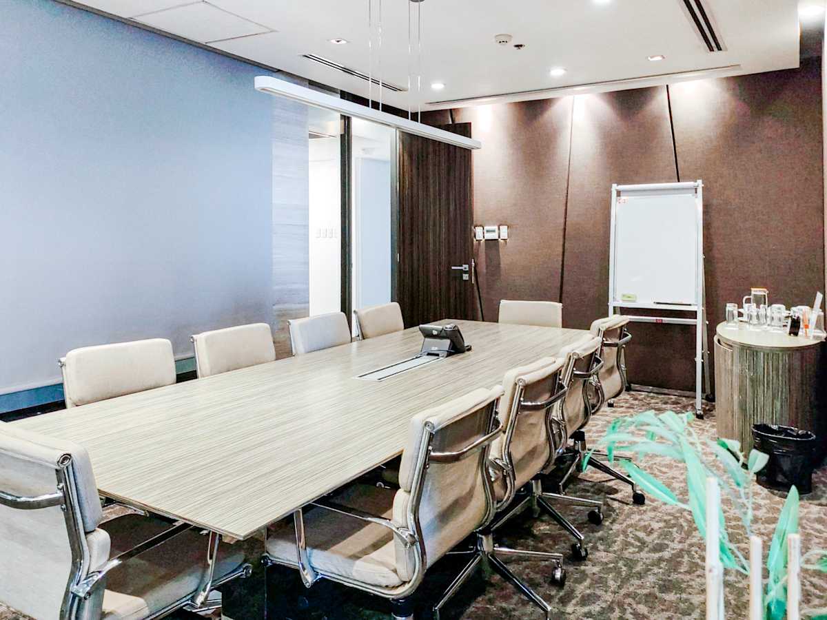 Modern conference room with a sleek table, comfortable seating, and ample lighting.