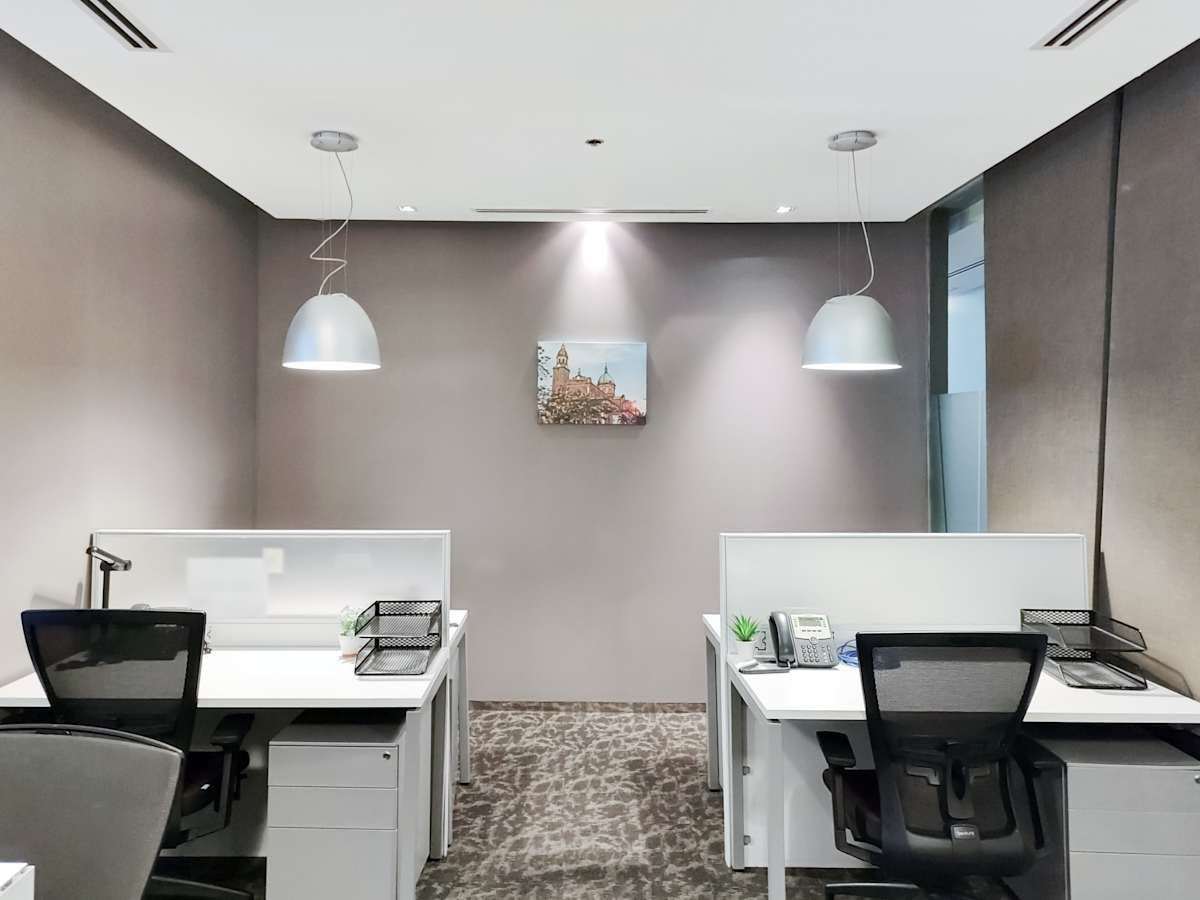 Modern workspace with sleek desks, ergonomic chairs, and ample lighting for productivity.