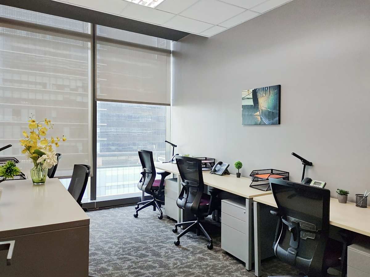 Modern office with natural light, ergonomic chairs, and spacious desks for productivity.