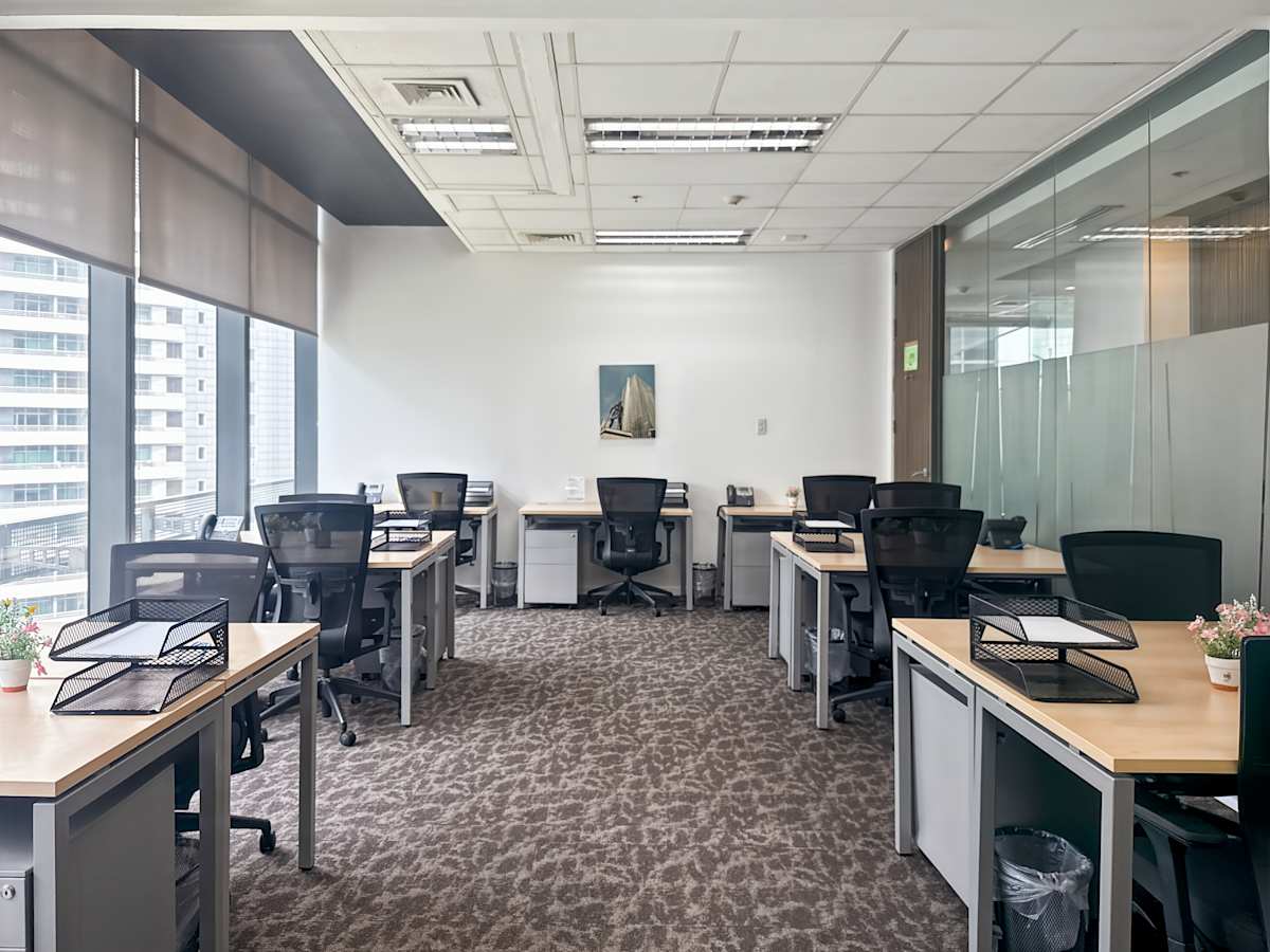 Modern workspace with ample natural light, sleek desks, and ergonomic chairs. Ideal for productivity.