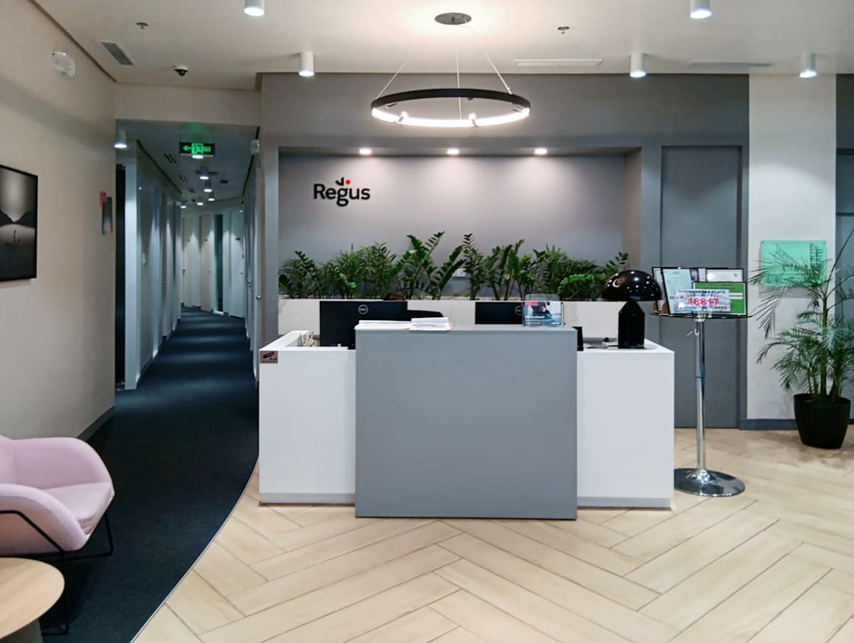 Modern reception area with sleek design, inviting lounge seating, and lush greenery.
