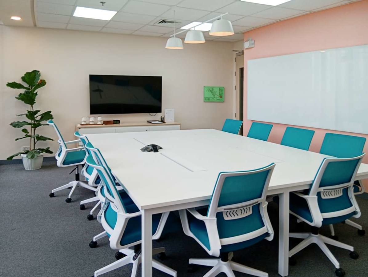 Modern conference room with stylish chairs, ample seating, and advanced AV setup. Ideal for collaboration.