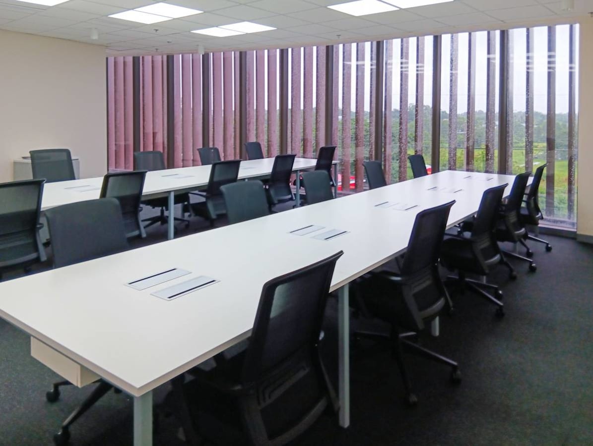 Modern open-plan office with ample natural light and sleek, ergonomic seating.