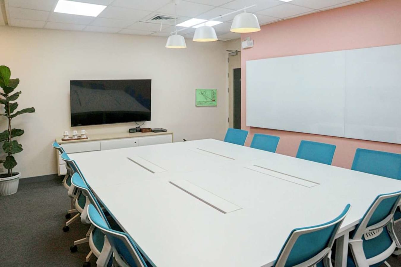 Modern conference room with sleek furniture, a large screen, and ample natural light.