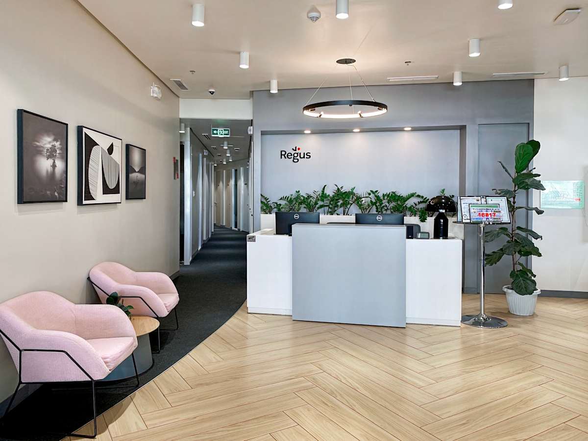 Modern reception with elegant lighting and seating, accented by greenery for a welcoming ambiance.