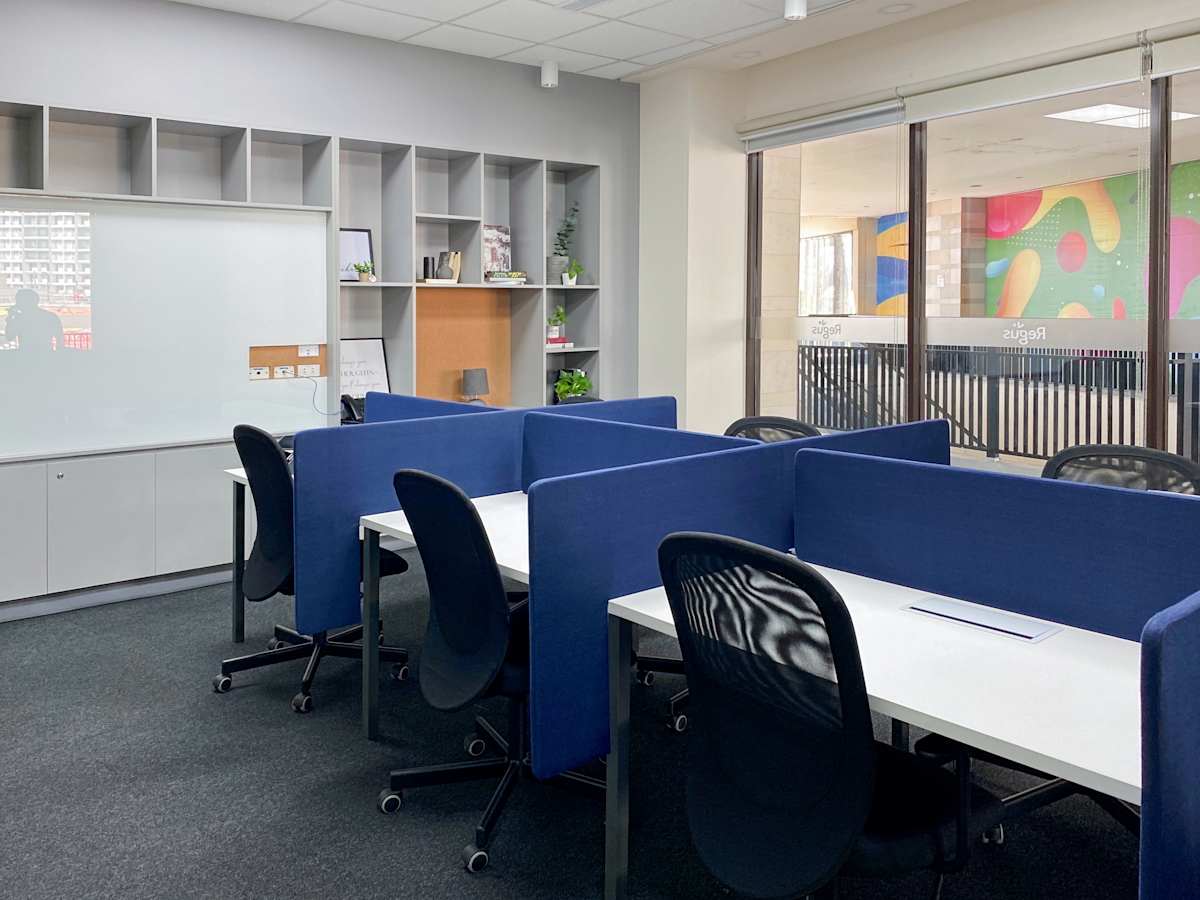 Modern coworking space with bright, open layout and sleek, blue-accented workstations.