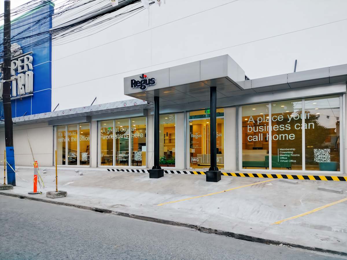 Modern office exterior with ample natural light and inviting entrance. Ideal for business needs.