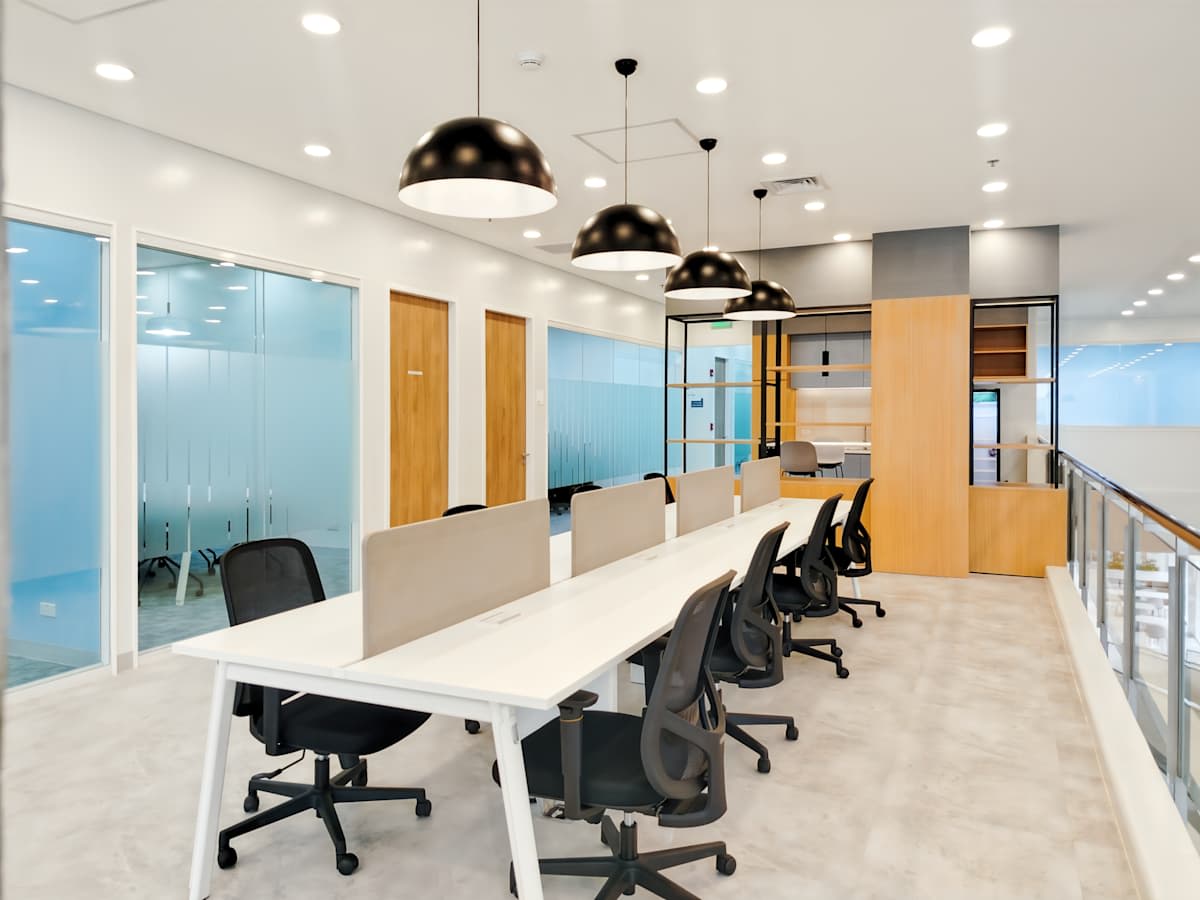 Bright coworking space featuring modern desks, ergonomic chairs, and stylish lighting.