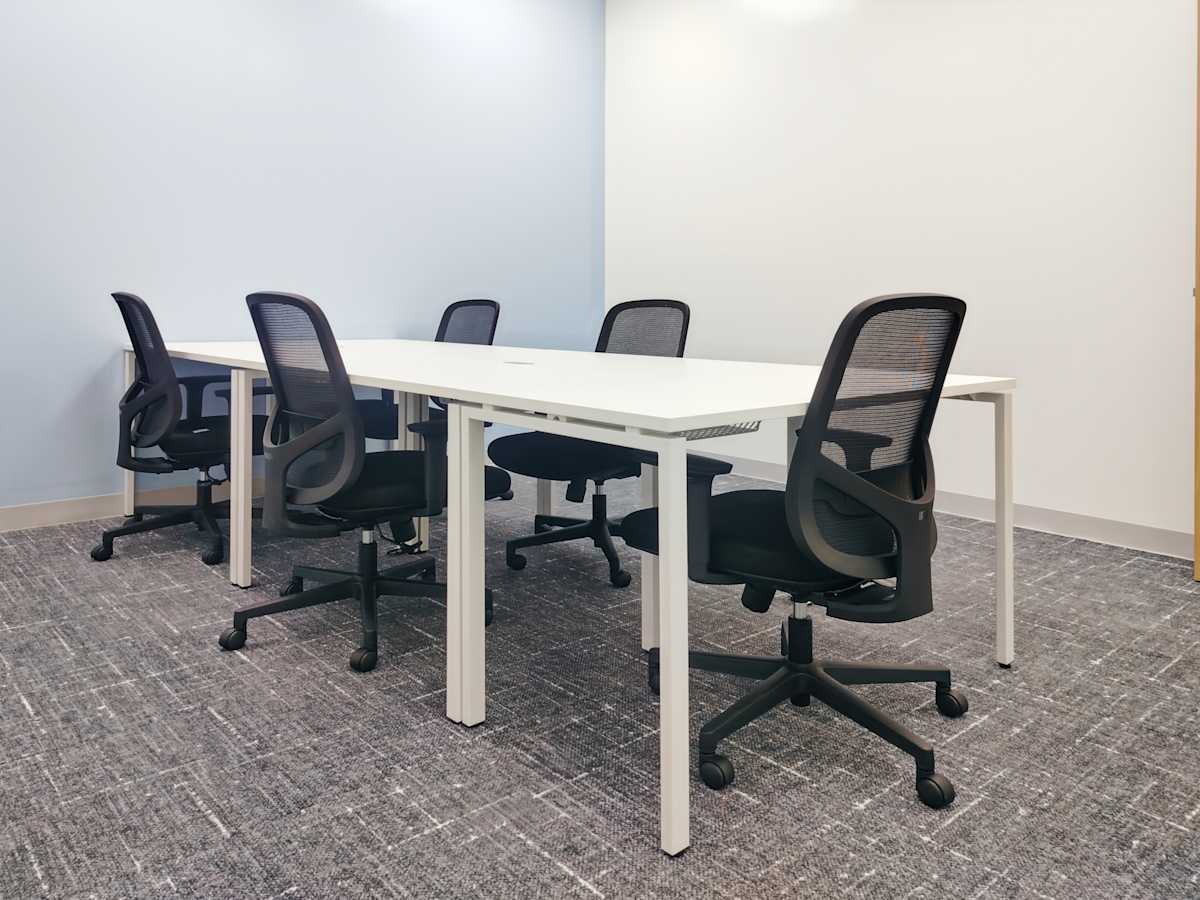 Modern workspace with sleek desks and ergonomic chairs, ideal for collaborative meetings.