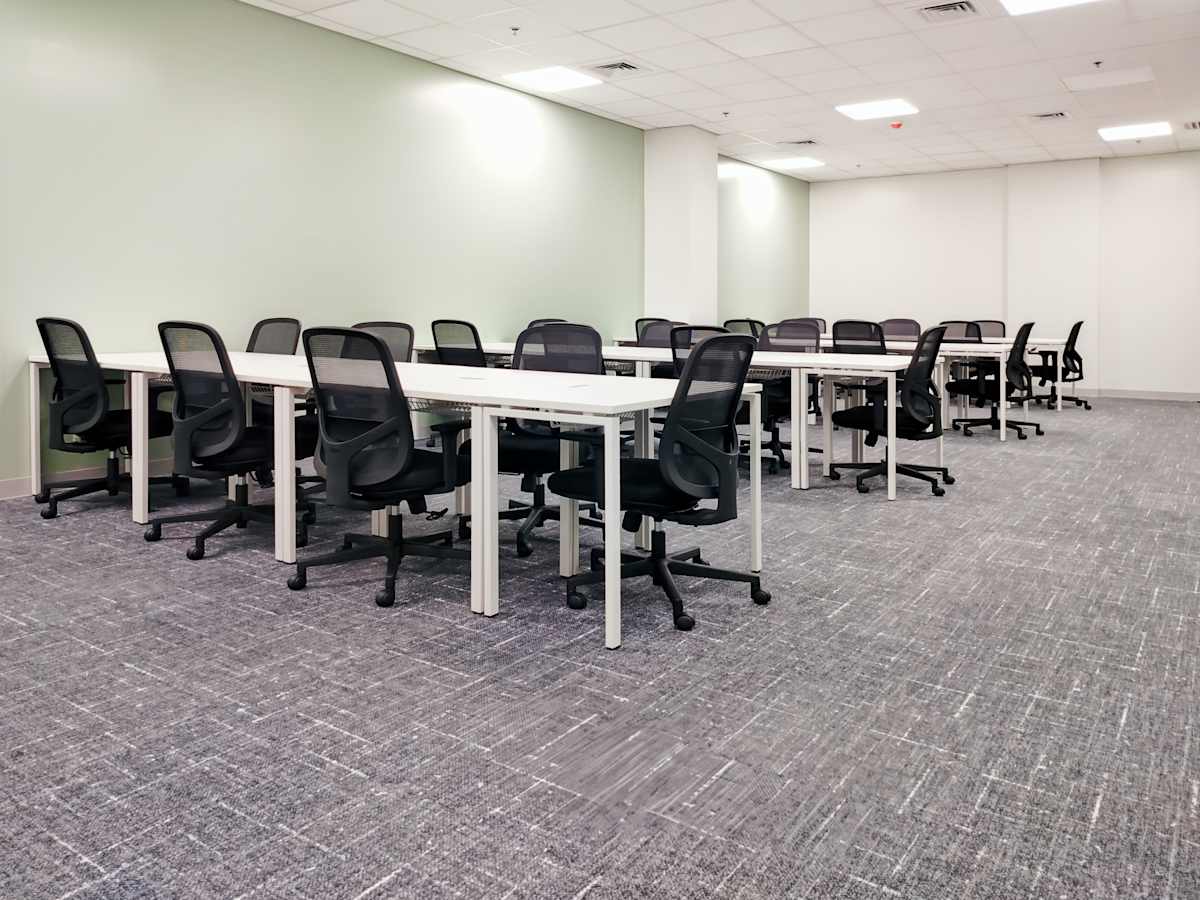Spacious coworking area with ample desks and ergonomic chairs, ideal for collaboration.